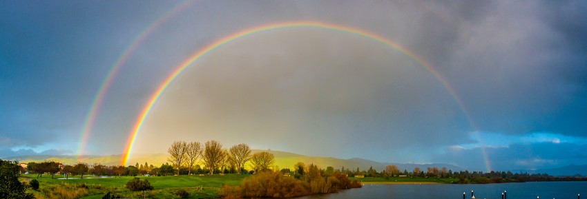 Ein beeindruckender Regenbogen spannt sich über eine idyllische Landschaft 