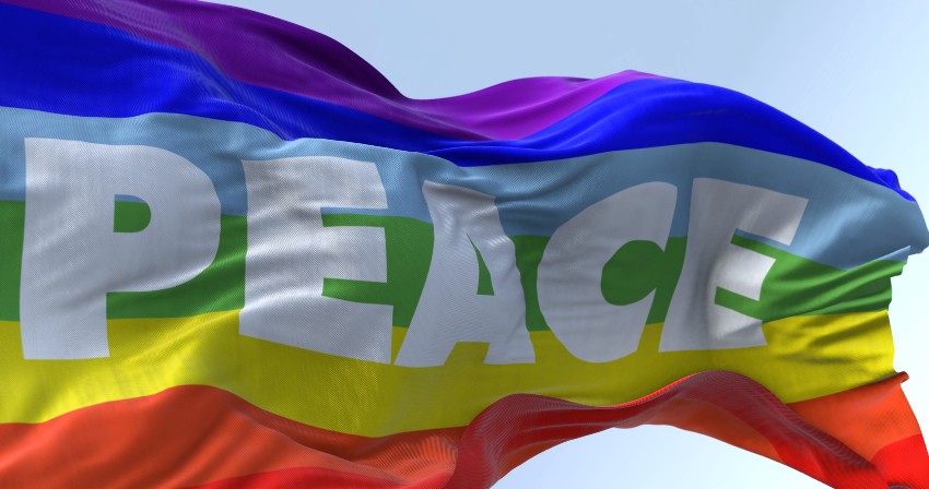 Regenbogenfahne mit dem Aufdruck: "PEACE" weht im Wind